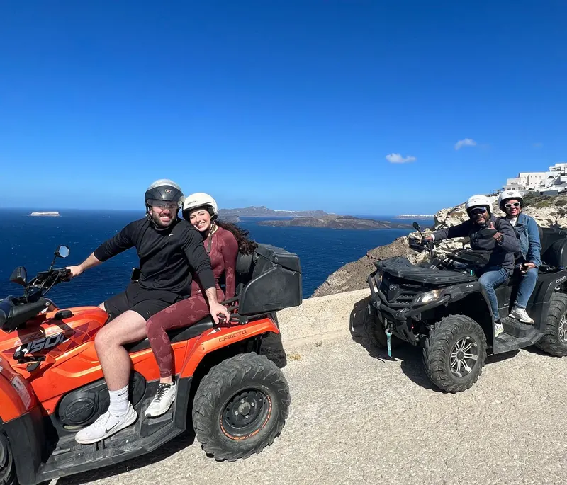 Rider on an orange quad bike at a Santorini caldera viewpoint