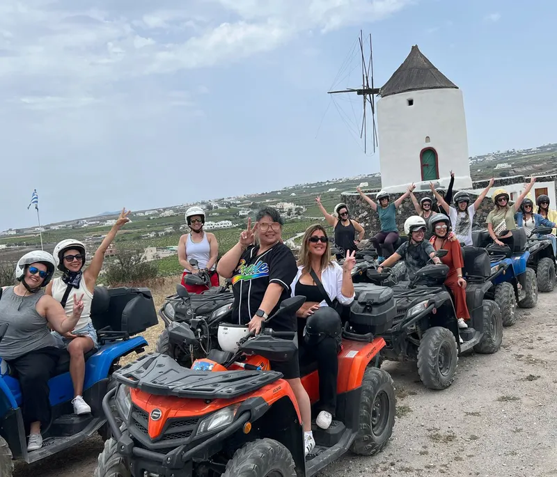 ATV tour group beside a traditional windmill near Megalochori, Santorini